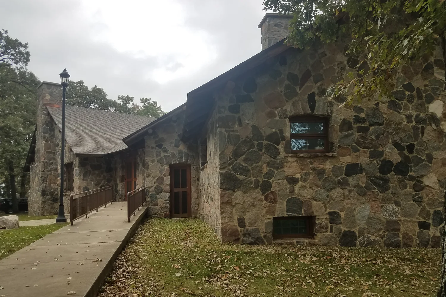 Stone lodge at Gull Point State Park beneath trees.