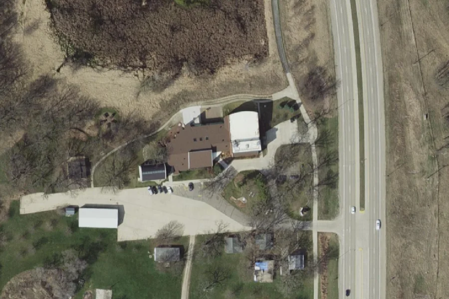 Leaf-off aerial view of the Pearson Lakes Art Center complex, arrival court and immediate grounds in Okoboji, Iowa, photographed in April 2017.
