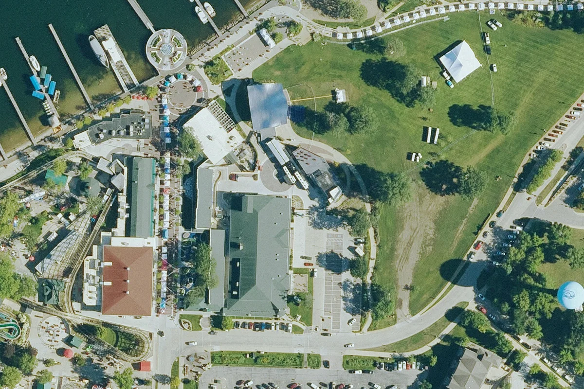 Aerial view of the Iowa Rock ’n Roll Hall of Fame and Museum’s shared building at Arnolds Park, with the neighboring music plaza and waterfront, photographed in August 2023.