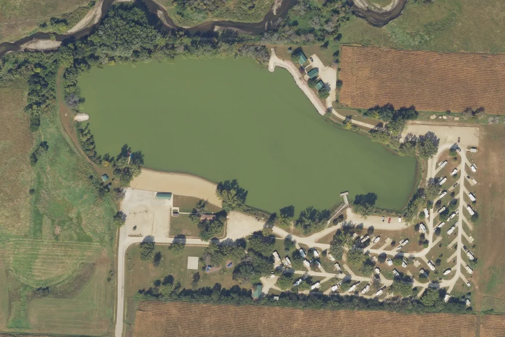 Natural-color aerial photograph of Scharnberg Park, with its pond, swimming beach, three cabins and campground, September 11, 2025.